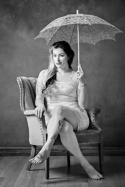 Woman holding an umbrella in a chair