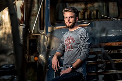 Senior guy in front of an old truck